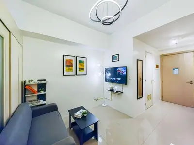 a living room with a blue couch and a tv at 1BR Condotel with Balcony at SM Light Residences #LT06 in Manila