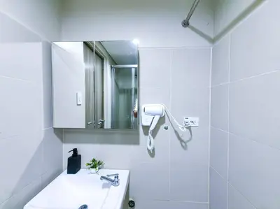 a white bathroom with a sink and a mirror at 1BR Condotel with Balcony at FAME Residences #FM09 in Manila