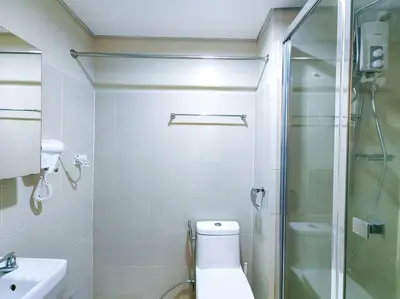 a bathroom with a toilet and a glass shower at 1BR Condotel with Balcony at FAME Residences #FM09 in Manila