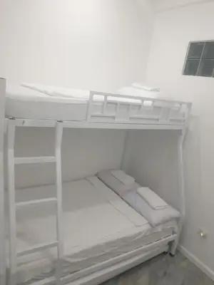 a white bunk bed in a white room at Bellas Apartment u1 in Manila