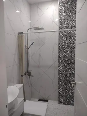 a bathroom with a shower with a toilet and a sink at Bellas Apartment u1 in Manila