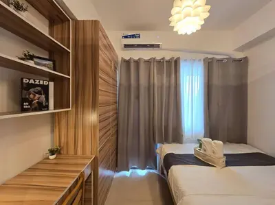 a small bedroom with two beds and a window at 1BR Condotel with Balcony at FAME Residences #FM14 in Manila