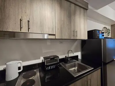a kitchen with a sink and a refrigerator at 1BR Condotel with Balcony at FAME Residences #FM14 in Manila
