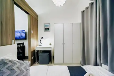 a bedroom with a white cabinet and a desk at 1BR Condotel with Balcony at FAME Residences #FM17 in Manila