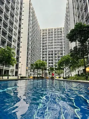 a large swimming pool in front of tall buildings at The Q's Place in Manila