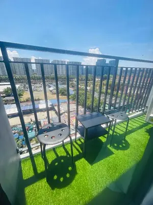 two chairs and tables on a balcony with a view at The Q's Place in Manila