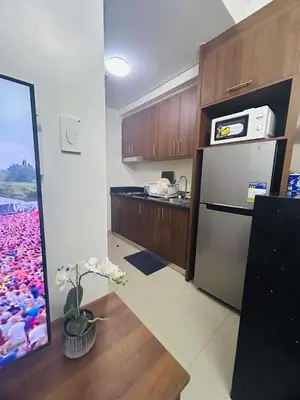 a kitchen with a stainless steel refrigerator and wooden cabinets at The Q's Place in Manila