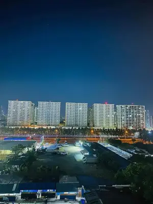 a city at night with tall white buildings at The Q's Place in Manila