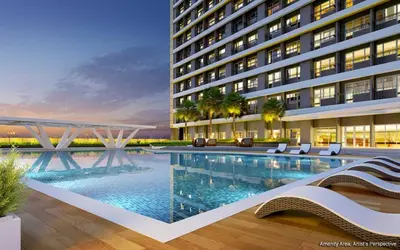 a hotel with a swimming pool in front of a building at SMDC Coast Residences in Manila