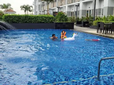 two children playing in a swimming pool with a swan at SMDC Coast Residences in Manila