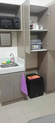 a small kitchen with a sink and a microwave at CasaMontero@UrbanDecaTowers EDSA in Manila