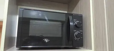 a microwave oven sitting inside of a cabinet at CasaMontero@UrbanDecaTowers EDSA in Manila