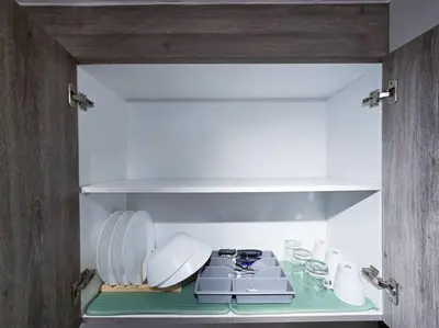 a kitchen with a stove and plates and glasses at 1BR Condotel with Balcony at FAME Residences #FM21 in Manila