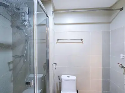 a bathroom with a toilet and a glass shower at 1BR Condotel with Balcony at FAME Residences #FM22 in Manila