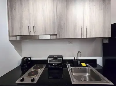 a kitchen with a sink and a counter top at 1BR Condotel with Balcony at FAME Residences #FM23 in Manila