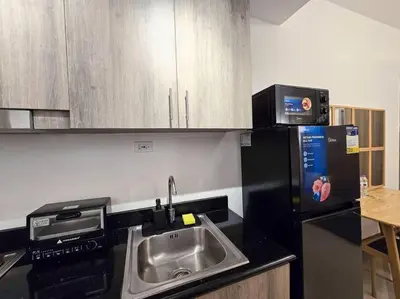 a kitchen with a sink and a microwave at 1BR Condotel with Balcony at FAME Residences #FM23 in Manila
