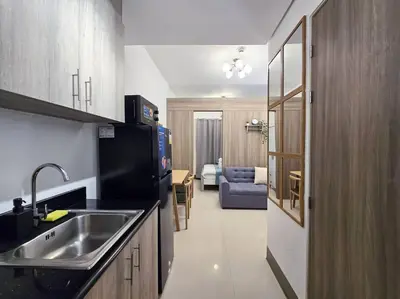 a kitchen with a sink and a couch in a room at 1BR Condotel with Balcony at FAME Residences #FM23 in Manila