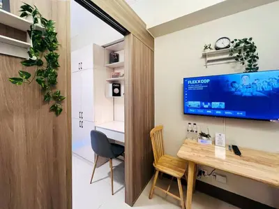 a room with a desk and a tv on the wall at 1BR Condotel with Balcony at FAME Residences #FM25 in Manila
