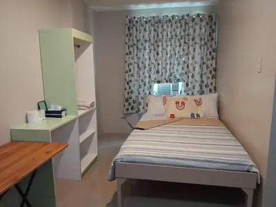 a small bedroom with a bed and a desk at AGB Anchorage Inn in Manila