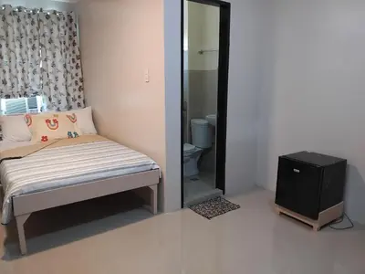 a small bedroom with a bed and a mirror at AGB Anchorage Inn in Manila