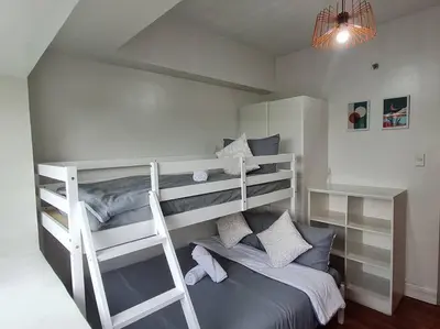 a bedroom with two bunk beds in a room at Big 2BR near Burgos Circle, Highstreet, St Lukes - B Parklane T1 in Manila