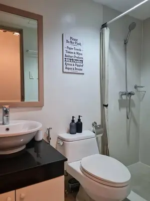 a bathroom with a toilet and a sink and a shower at Big 2BR near Burgos Circle, Highstreet, St Lukes - B Parklane T1 in Manila