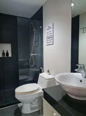 a bathroom with a toilet and a sink and a shower at Big 2BR near Burgos Circle, Highstreet, St Lukes - B Parklane T1 in Manila