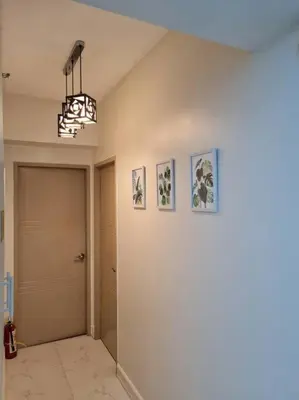 a hallway with a door and pictures on the wall at Big 2BR near Burgos Circle, Highstreet, St Lukes - B Parklane T1 in Manila