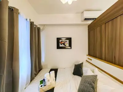 a hotel room with a bed and a window at 1BR Condotel with Balcony at FAME Residences #FM08 in Manila