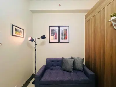 a living room with a purple couch and a lamp at 1BR Condotel with Balcony at FAME Residences #FM26 in Manila