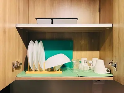 a shelf with plates and utensils in a cabinet at 1BR Condotel with Balcony at FAME Residences #FM27 in Manila