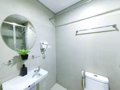 a white bathroom with a sink and a mirror at 1BR Condotel with Balcony at FAME Residences #FM28 in Manila