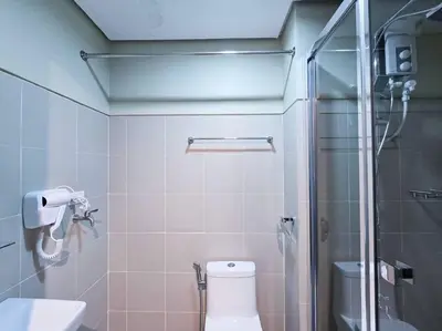 a bathroom with a toilet and a glass shower at 1BR Condotel with Balcony at FAME Residences #FM29 in Manila