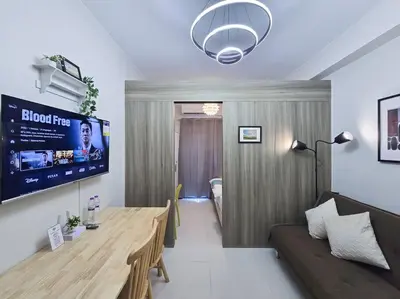 a living room with a wooden table and a couch at 1BR Condotel with Balcony at FAME Residences #FM29 in Manila