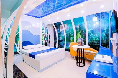 a bedroom with a bed and a table in a room at Hotel Dreamworld Las Pinas in Manila