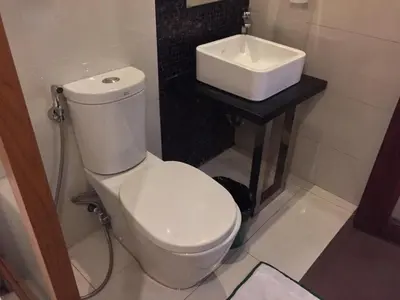 a bathroom with a white toilet and a sink at Eurotel Las Pinas in Manila