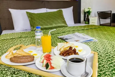 a tray of breakfast food on a bed at Eurotel Las Pinas in Manila