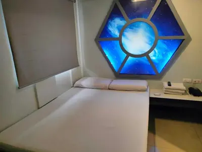 a room with a window and a bed with a table at Astrotel Guadalupe in Manila