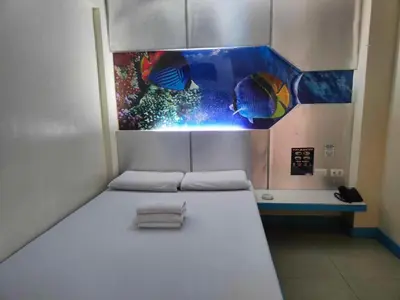 a bed in a room with a fish tank at Astrotel Guadalupe in Manila