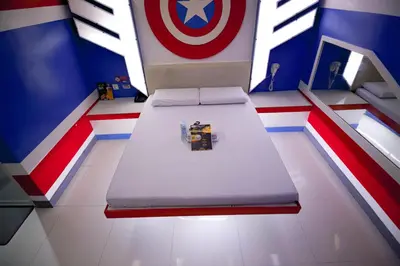 a room with a bed with a captain america mural at Astrotel Divisoria in Manila
