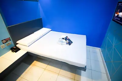 a white bed in a room with a blue wall at Astrotel Divisoria in Manila