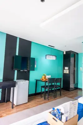 a kitchen with blue walls and a table with chairs at Hotel Dreamworld Araneta Cubao in Manila