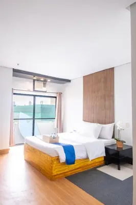 a bedroom with a large bed and a large window at Hotel Dreamworld Araneta Cubao in Manila