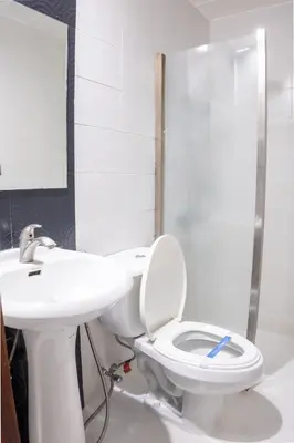 a bathroom with a toilet and a sink at Hotel Dreamworld Araneta Cubao in Manila