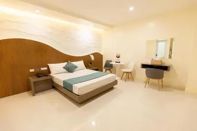 a bedroom with a bed and a desk in it at Hotel Dreamworld East Ortigas in Manila