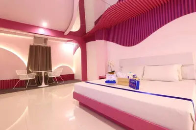 a bedroom with a large bed with purple walls at Hotel Dreamworld East Ortigas in Manila