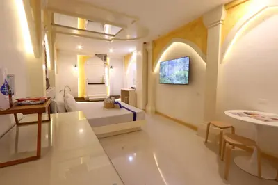 a living room with a bed and a table at Hotel Dreamworld East Ortigas in Manila