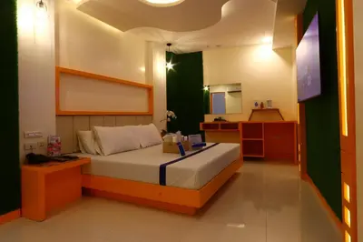 a small bedroom with a bed and a mirror at Hotel Dreamworld East Ortigas in Manila