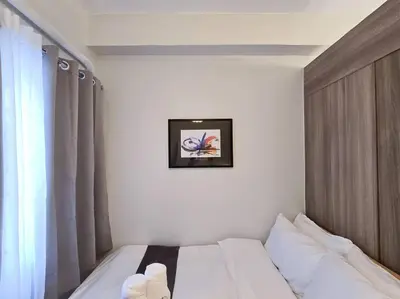a bed in a room with a picture on the wall at 1BR Condotel with Balcony at FAME Residences #FM30 in Manila
