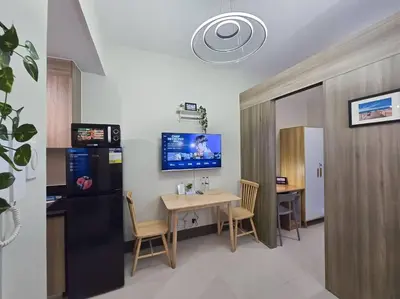 a room with a table and a kitchen with a refrigerator at 1BR Condotel with Balcony at FAME Residences #FM30 in Manila